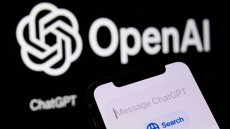 Ein Smartphone zeigt das neue Such-Feature von ChatGPT, im Hintergrund das Firmenlogo von OpenAI. | Bild: picture alliance / NurPhoto | Matteo Della Torre Ein Smartphone zeigt das neue Such-Feature von ChatGPT, im Hintergrund das Firmenlogo von OpenAI.