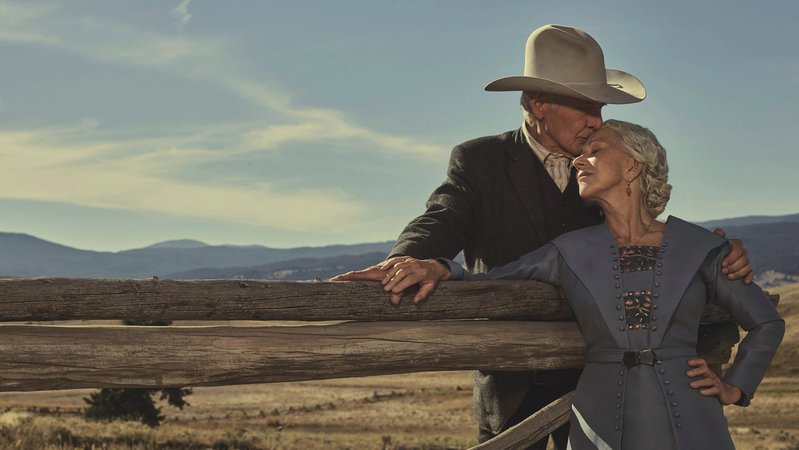 Filmstar Helen Mirren als Cara und Harrison Ford als Jacob Dutton am Zaun ihrer Ranch vor der weiten Landschaft Montanas