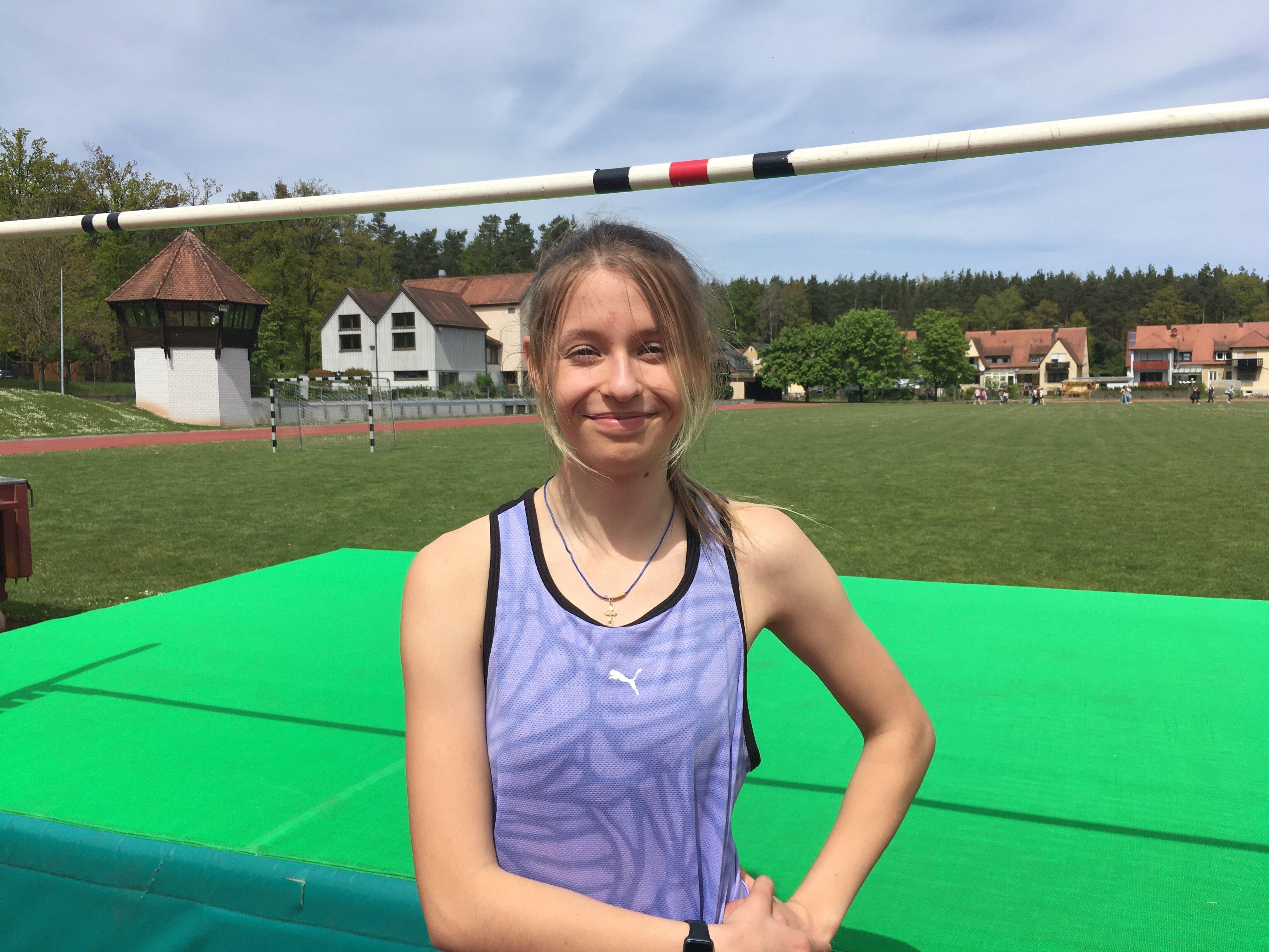 Maryna Kovtunova steht vor einer Hochsprungmatte, über sich eine Hochsprungstange.