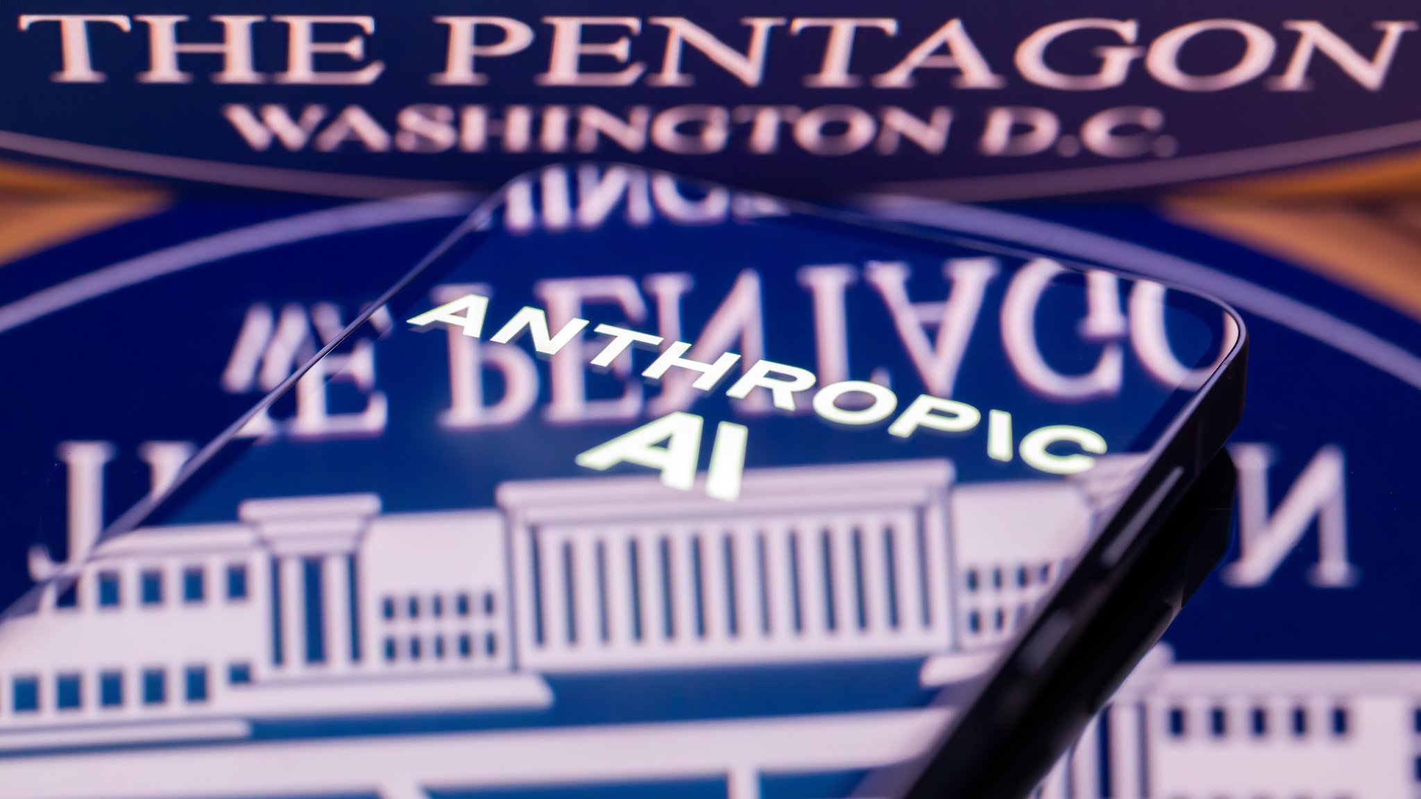 Ein Smartphonebildschirm spiegelt sich in einem Schriftzg "The Petagon Washington D.C"