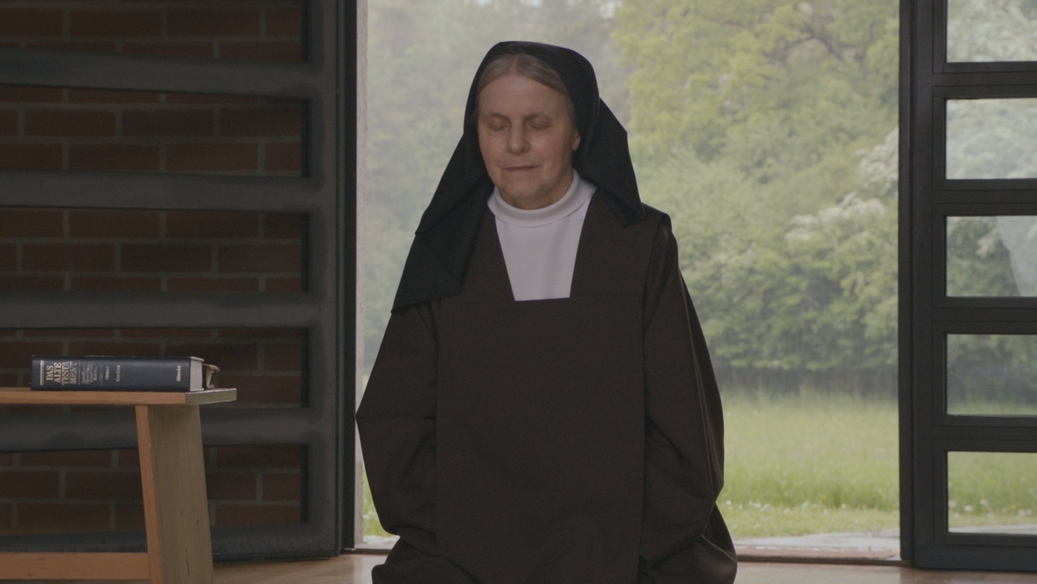 Der Glaube erlaubt es, mit sich ins Reine zu kommen. Eine Nonne betet in "Wo ist Gott?" (Filmszene).