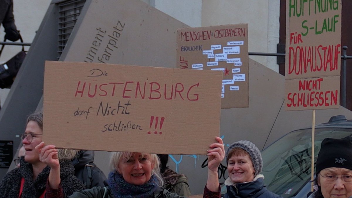 Demonstranten in Donaustauf mit Schildern, wie "Die Hustenburg darf nicht schließen". Sie protestieren gegen die mögliche Schließung der Lungenfachklinik.