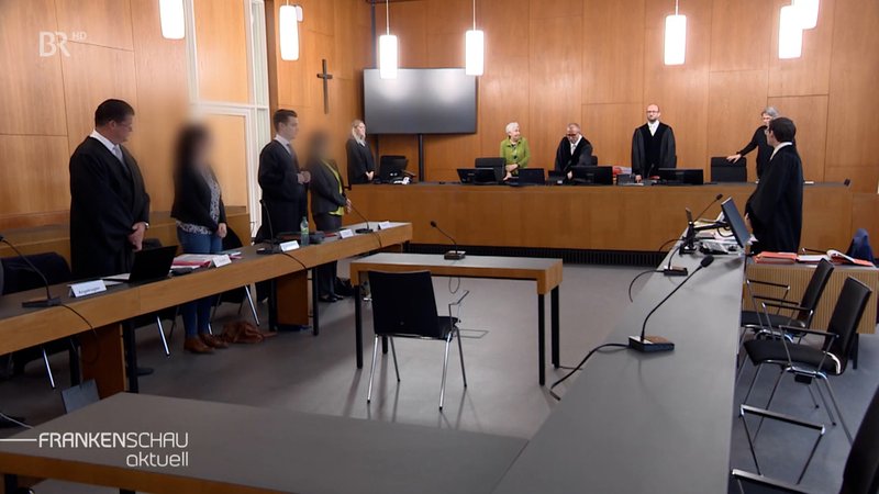 Menschen stehen im Gerichtssaal. | Bild: BR Menschen stehen im Gerichtssaal.