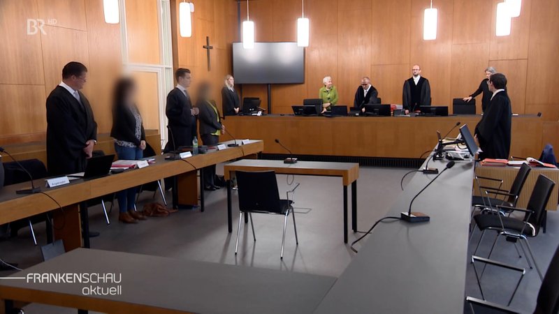 Menschen stehen im Gerichtssaal. | Bild: BR Menschen stehen im Gerichtssaal.