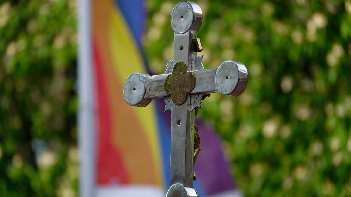 Kreuz vor Regenbogenfahne (Symbolbild)