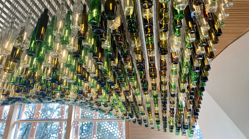 Recycling-Kunst am Bau: Die gläserne "Welle" aus 900 Altglasflaschen von Tom Kristen empfängt als Blickfang im Foyer die Besucher des NAWAREUM