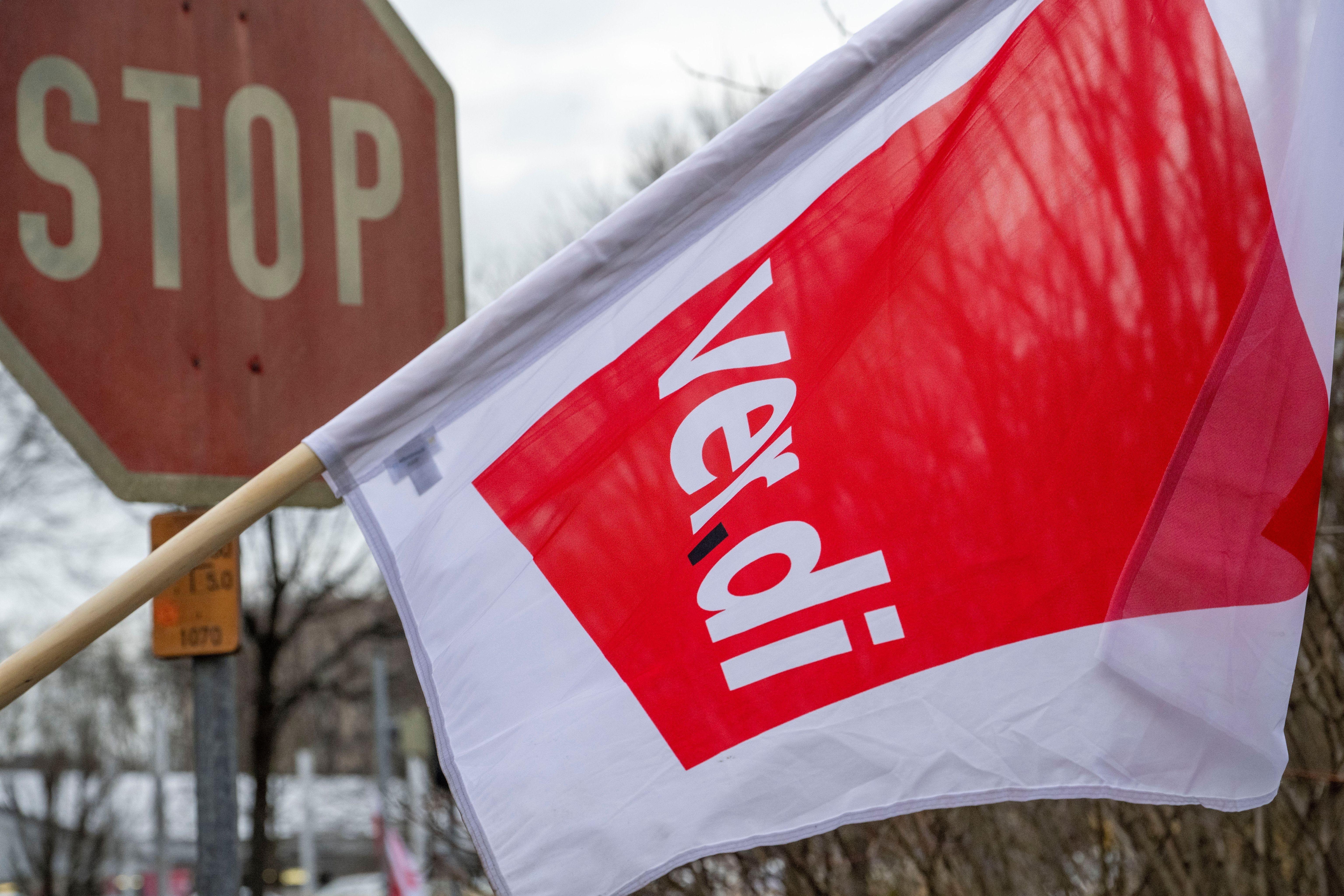 Eine Flagge der Gewerkschaft Verdi weht vor einem Stoppschild in Augsburg.