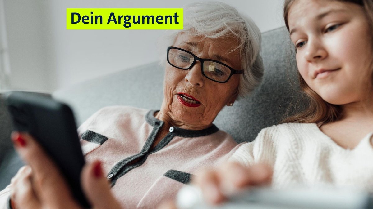 Eine Frau sitzt mit einem Mädchen auf der Couch. Sie sehen beide auf das Handy der Frau. (Symbolbild)