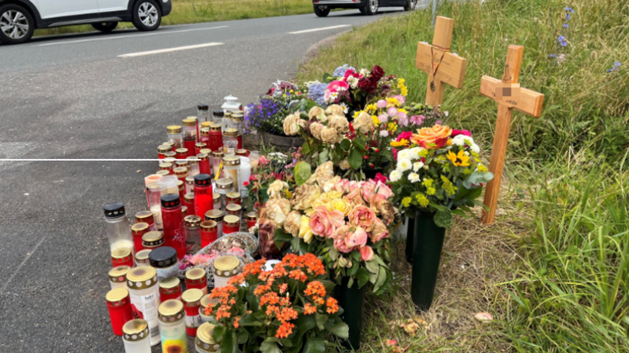 Holzkreuze, Grablichter und Blumen an der sogenannten "Baumkurve"