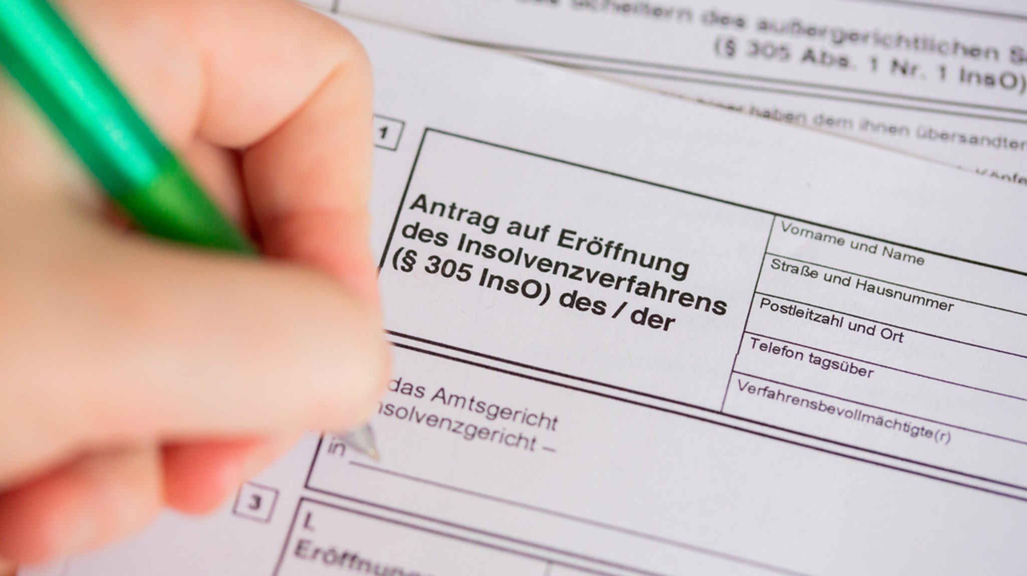 Eine Person füllt einen Insolvenzantrag aus.