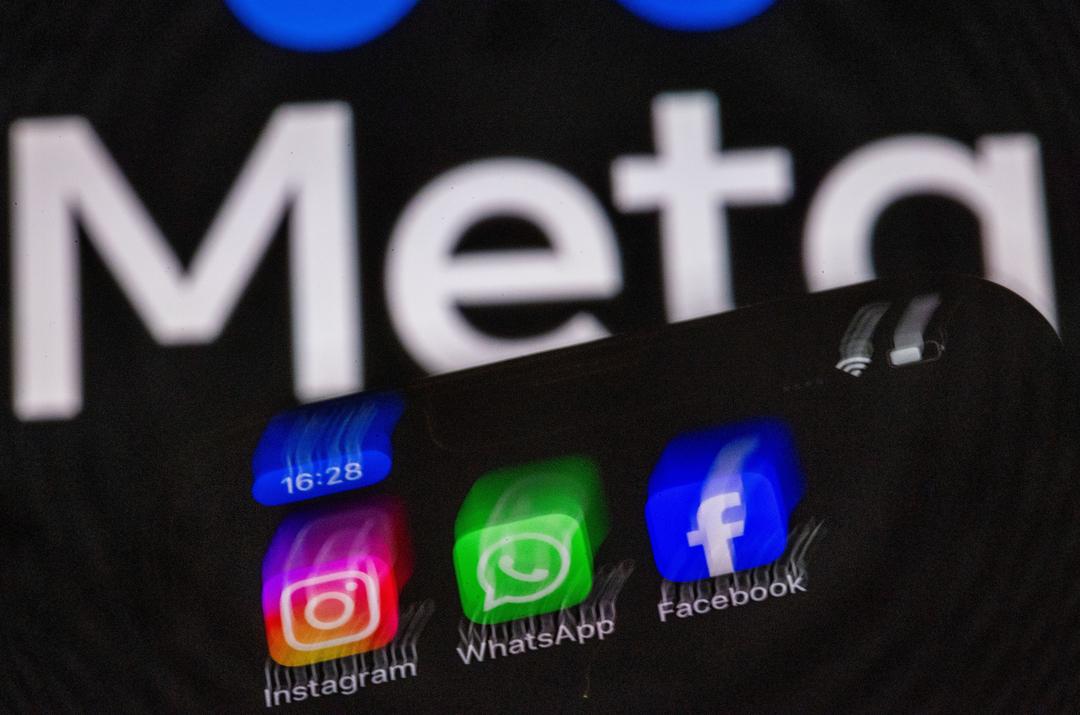 Die Apps Instagram, Facebook und WhatsApp sind auf dem Display eines Smartphones vor dem Logo des Internetkonzerns Meta zu sehen.