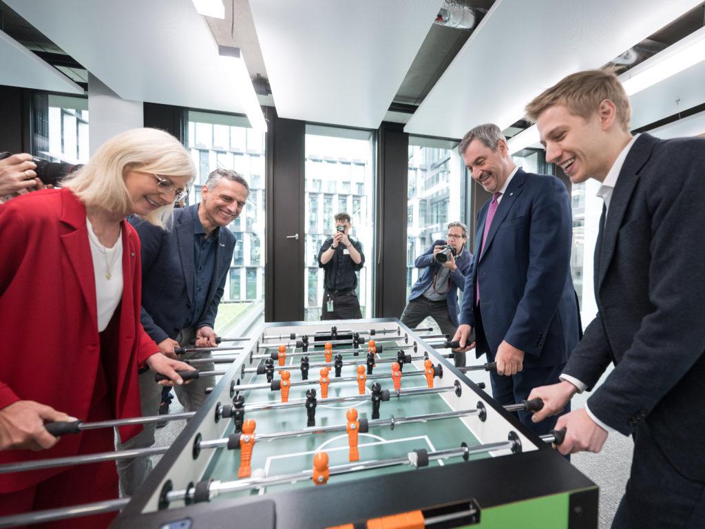 Dominik Krause und Markus Söder im Tischkicker-Spiel gegen Arbeitsministerin Ulrike Scharf (CSU) und Amazon-Deutschland-Chef Rocco Bräuniger 