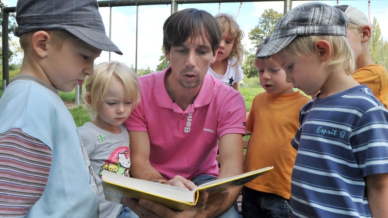 Männlicher Erzieher liest Kindern in eienr Kindertagesstätte vor (Symbolbild) | Bild: picture alliance / dpa | Martin Schutt Männlicher Erzieher liest Kindern in eienr Kindertagesstätte vor (Symbolbild)