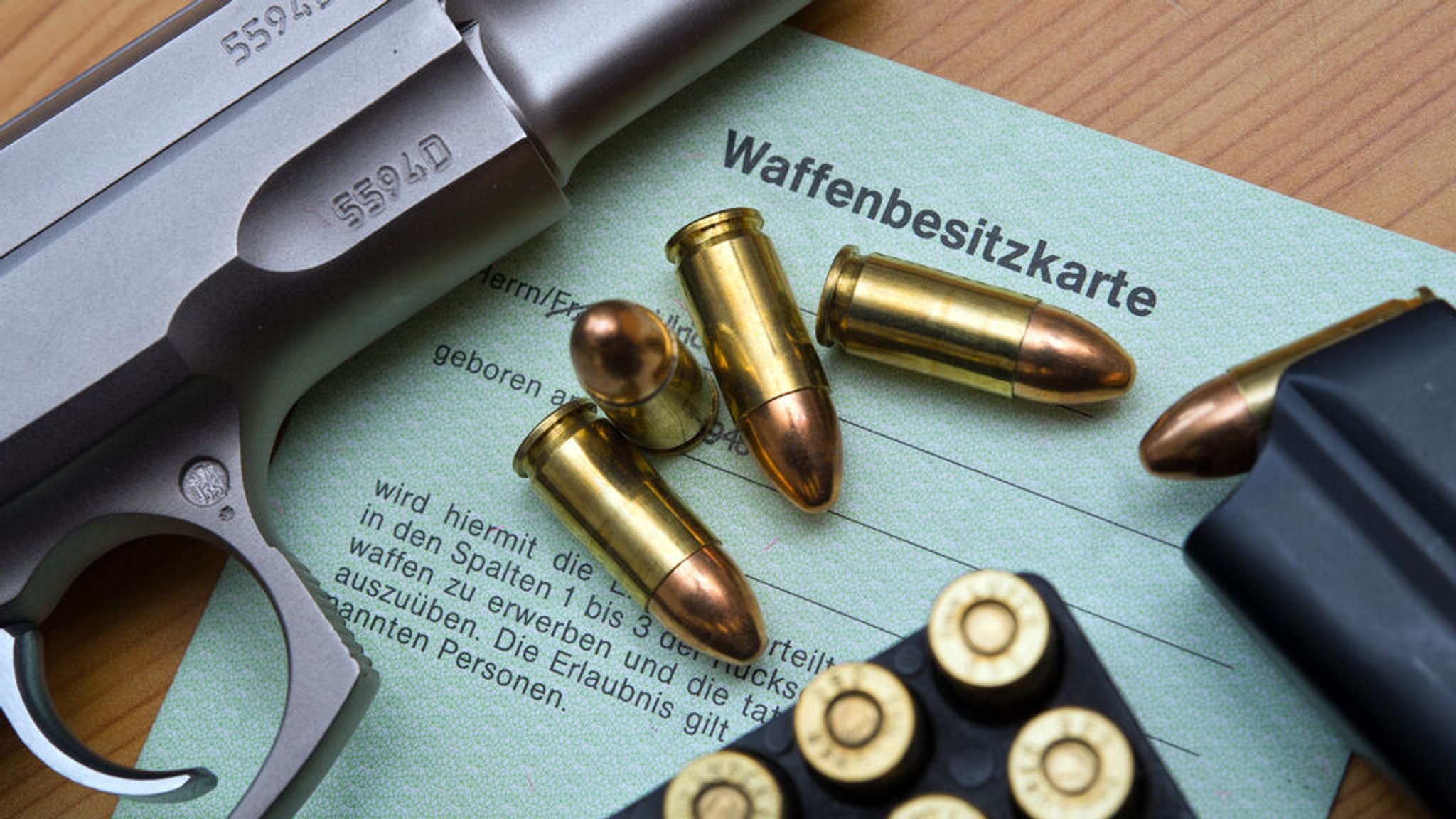 ARCHIV - 04.03.2014, Brandenburg, Frankfurt (Oder): Eine Kaliber-9 mm-Pistole, Patronen und ein Magazin liegen auf einer Waffenbesitzkarte. (zu dpa: «Rund 176 600 Waffen in Schleswig-Holstein registriert») Foto: Patrick Pleul/dpa-Zentralbild/dpa +++ dpa-Bildfunk +++