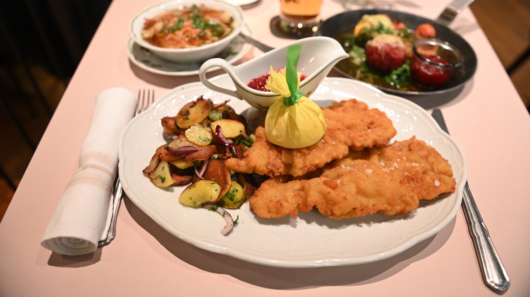 Ein Wiener Schnitzel steht auf einem gedeckten Tisch.