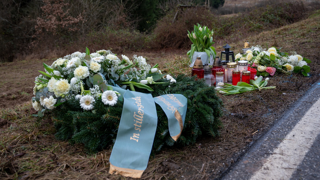 Rheinland-Pfalz, Kusel: Ein Kranz sowie Blumen und Kerzen liegen am Tatort an der Kreisstraße 22 bei Ulmet (Rheinland-Pfalz) zum Gedenken.