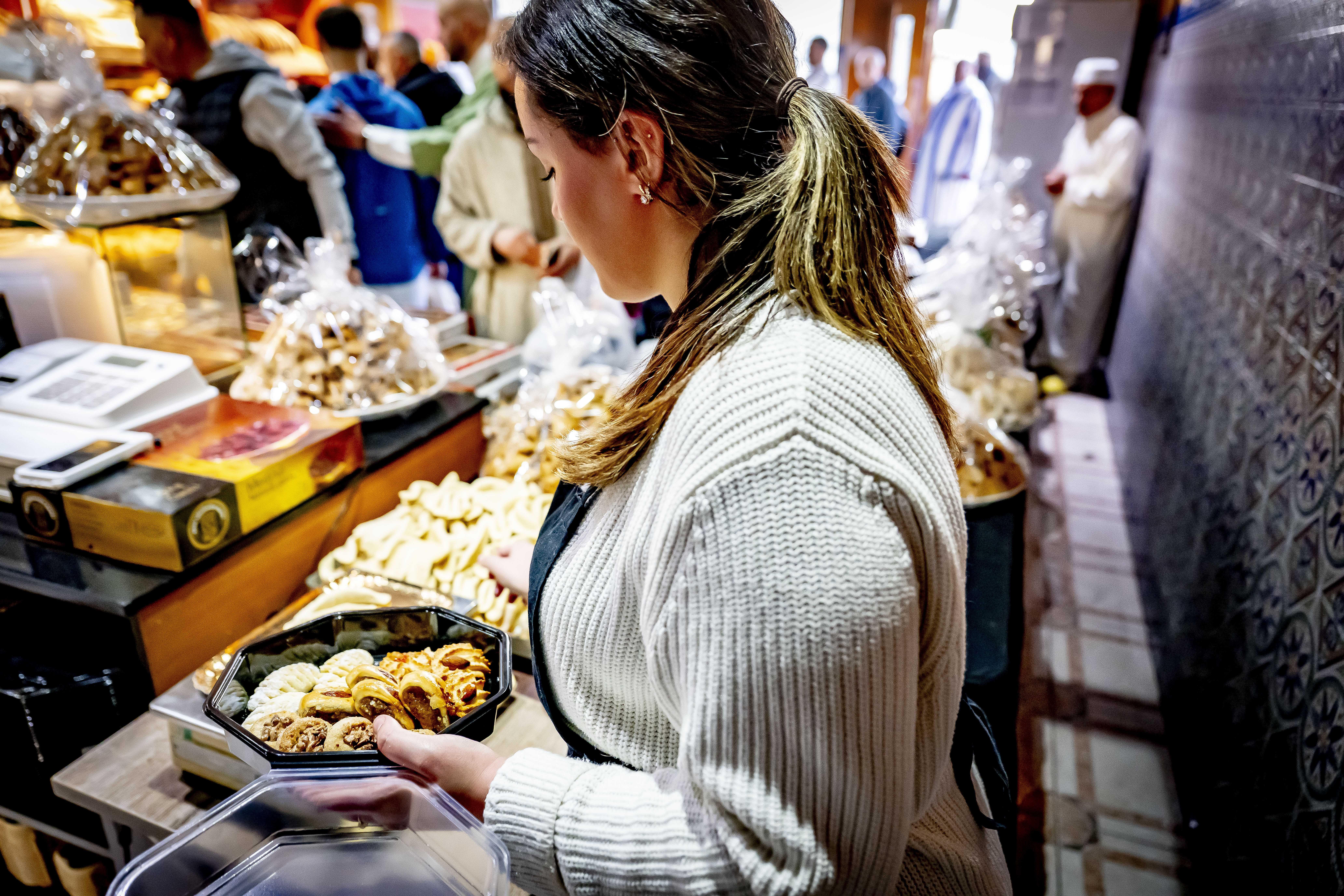 Eine Frau füllt eine Schale mit Süßgebäck.