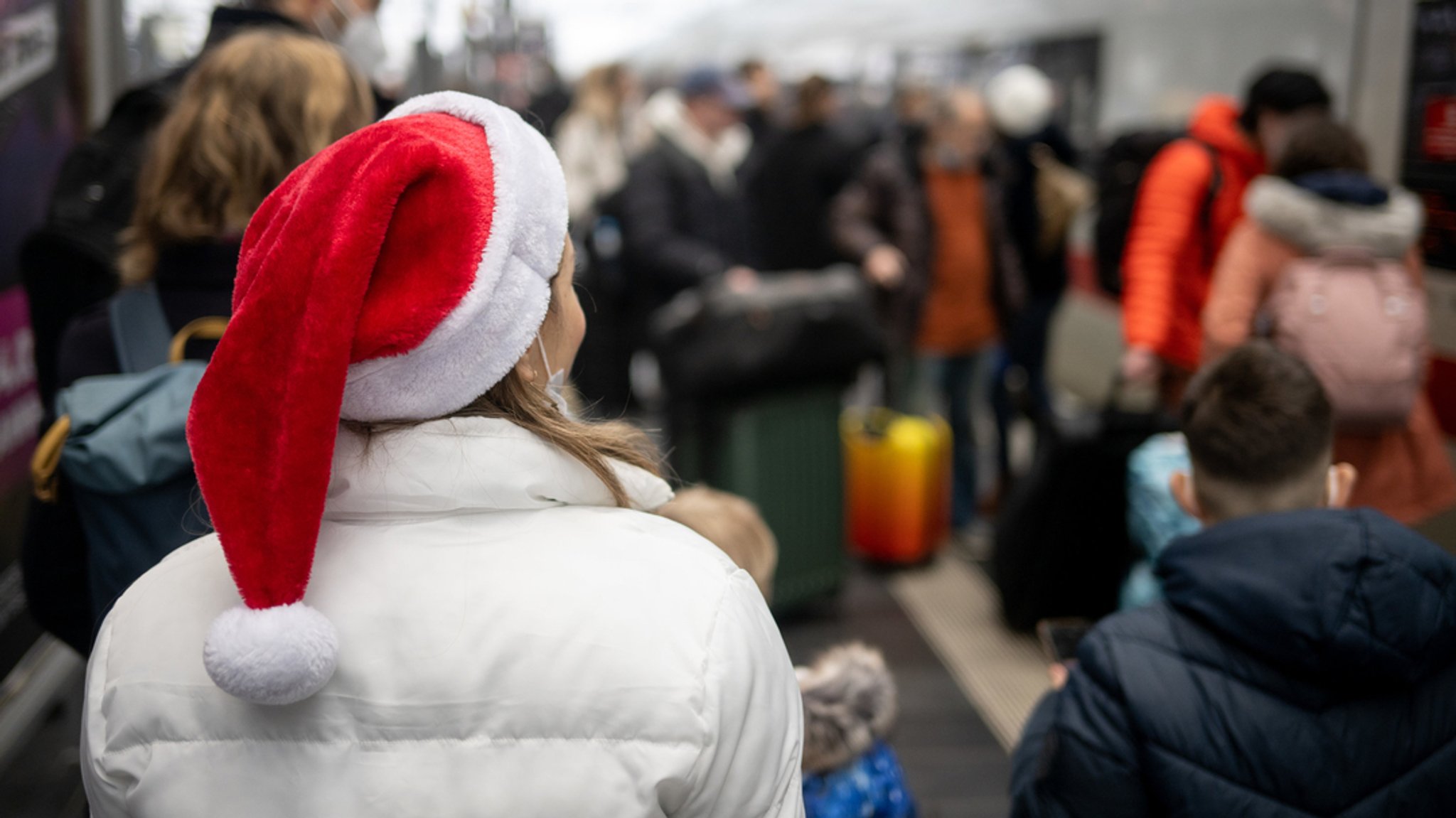  Ein Frau mit Nikolausmütze wartet am Frankfurter Hauptbahnhof darauf, in einen ICE zu steigen. (Archivbild)