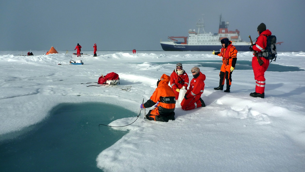 Wissenschaftler vom Alfred-Wegener-Institut beproben einen Schmelztümpel auf arktischem Meereis. 
