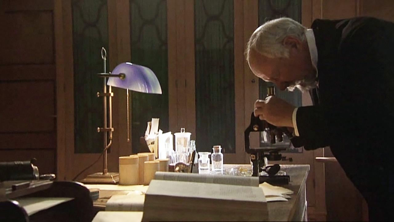 Ein Mann beugt sich über ein Mikroskop.