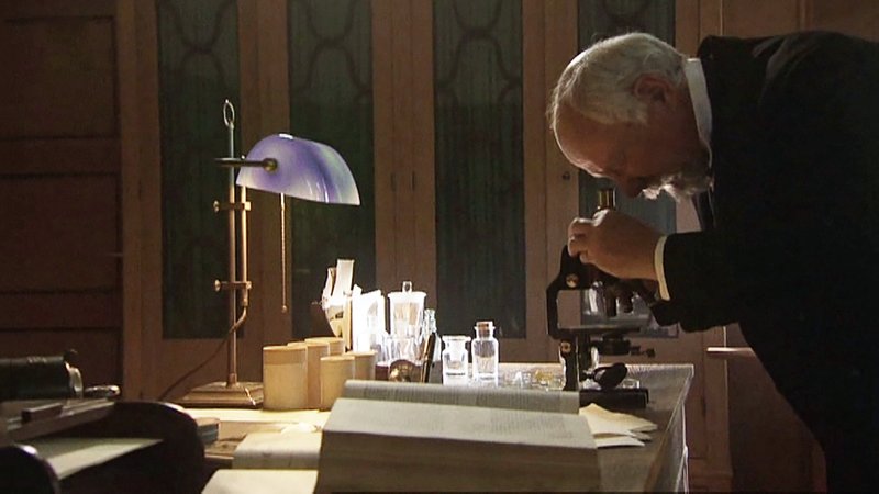 Ein Mann beugt sich über ein Mikroskop. | Bild: Bayerischer Rundfunk Ein Mann beugt sich über ein Mikroskop.