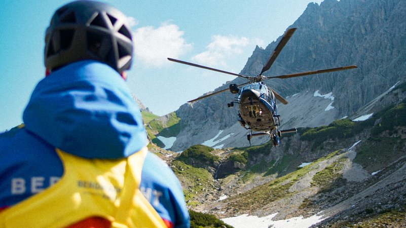 Landender Helikopter und Retter von der Bergwacht in den Allgäuer Hochalpen