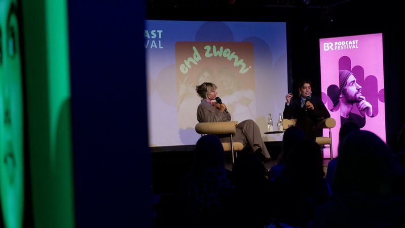 Podcaster auf der Bühne. | Bild: BR Podcaster auf der Bühne.