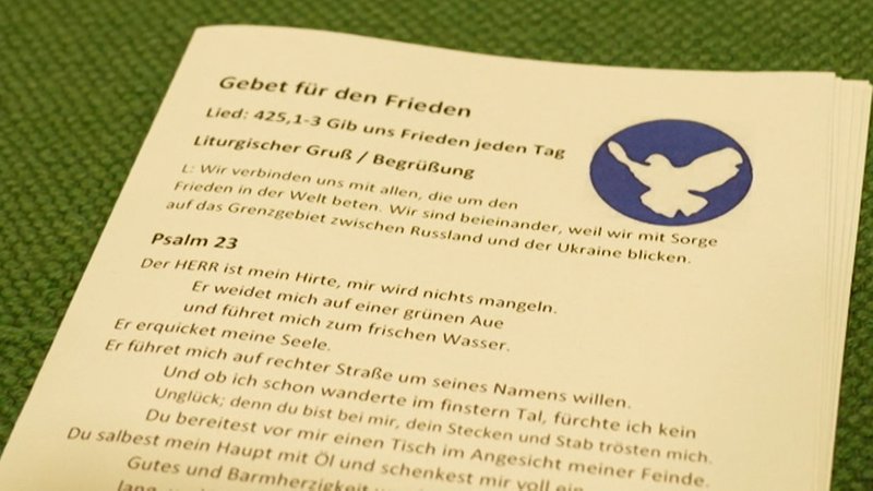 Ein Flugblatt mit der Überschrift "Gebet zum Frieden" liegt aus.