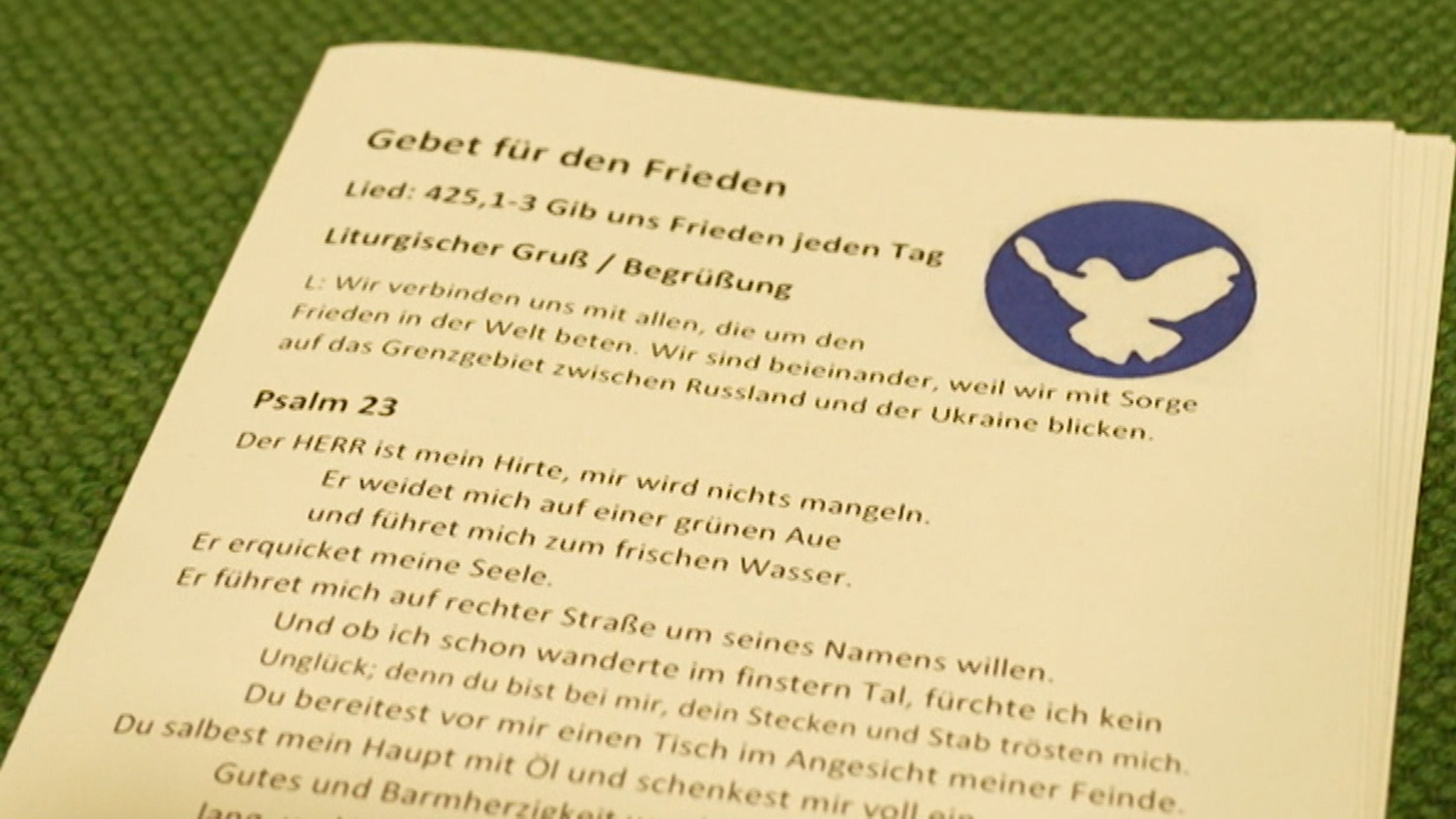 Ein Flugblatt mit der Überschrift "Gebet zum Frieden" liegt aus.