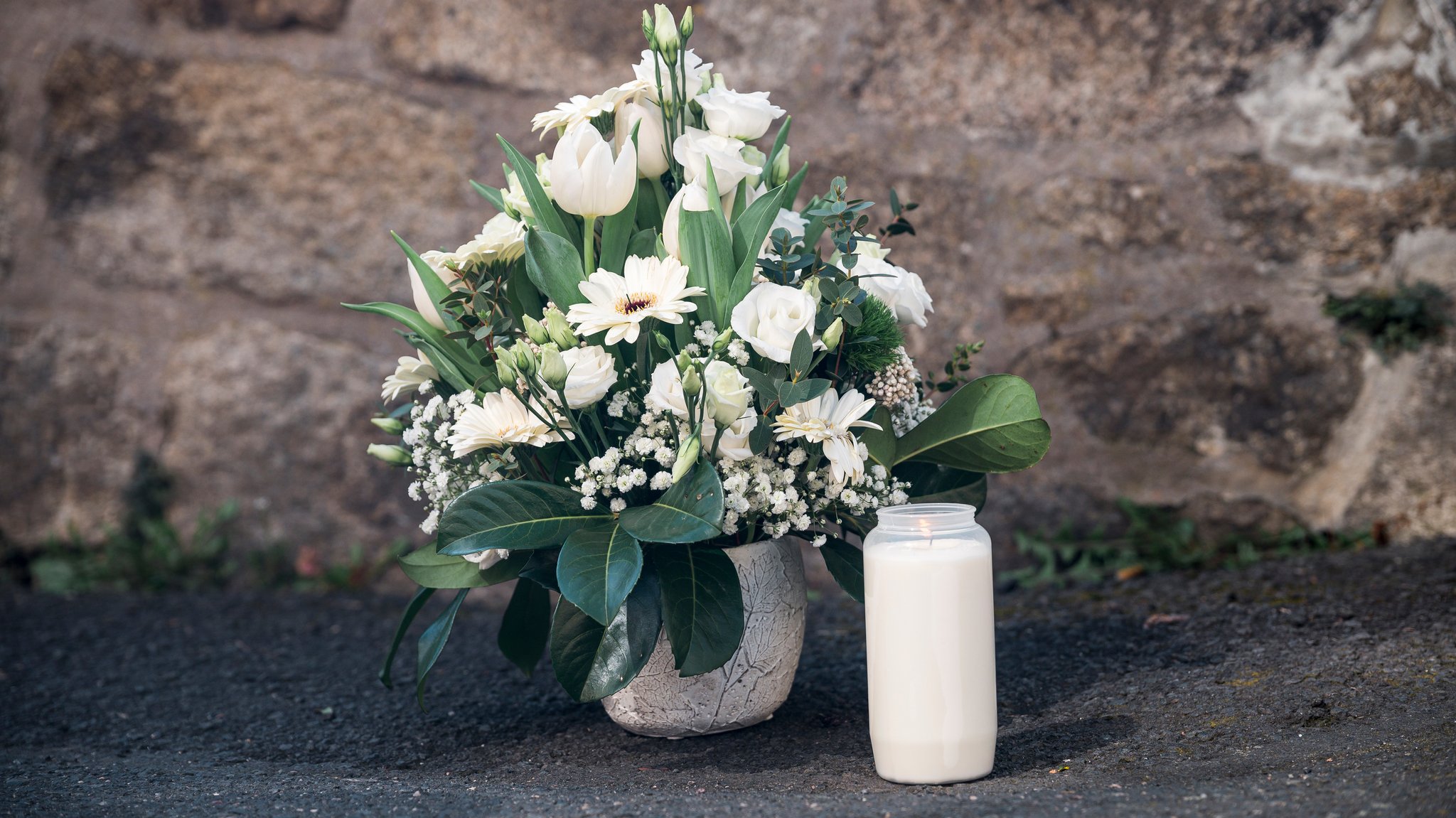 Ein Strauß Blumen und eine Kerze vor dem Kinder- und Jugendzentrum Wunsiedel (2023).