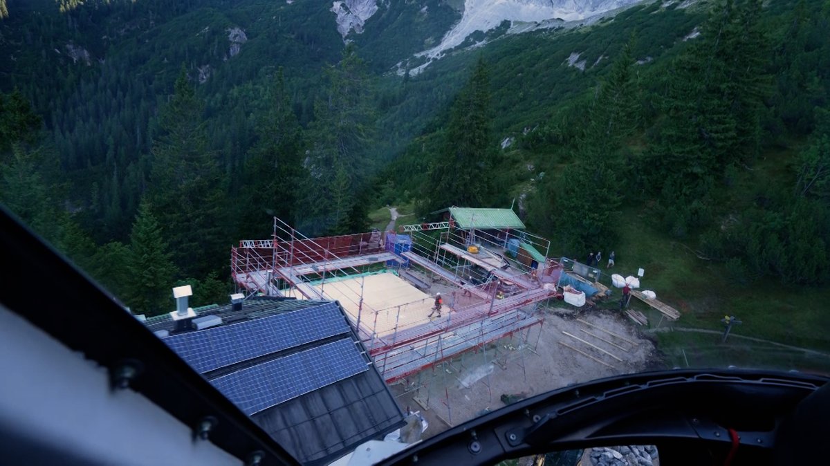 Blick aus dem Hubschrauber auf die Baustelle in den Bergen.