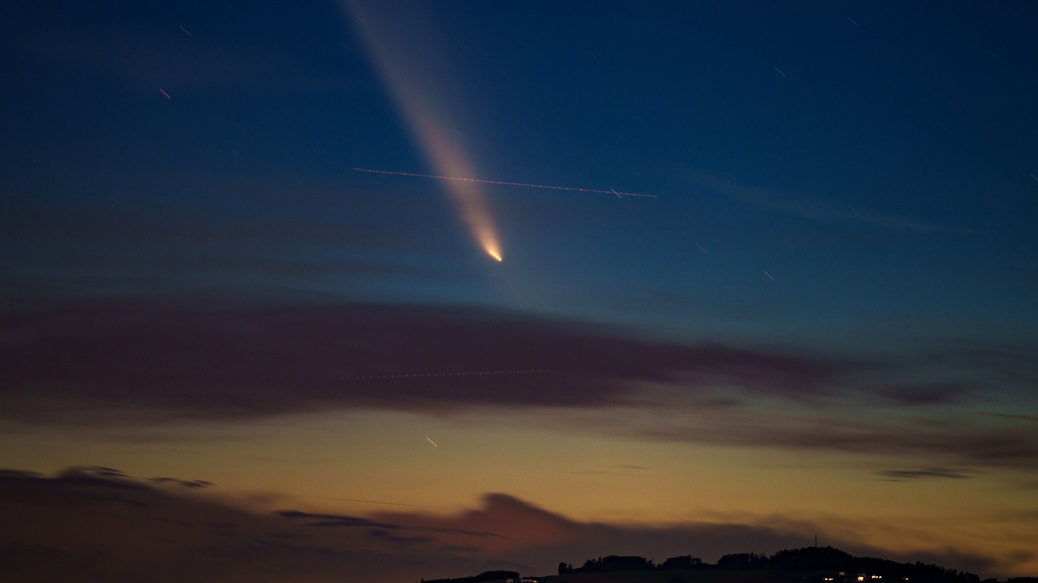 Der Komet Tsuchinshan-ATLAS mit hellem Kern und weißlichem Schweif vor einem Sternenhintergrund mit letztem Tageslicht in Österreich - Archivbild vom 13.10.2024