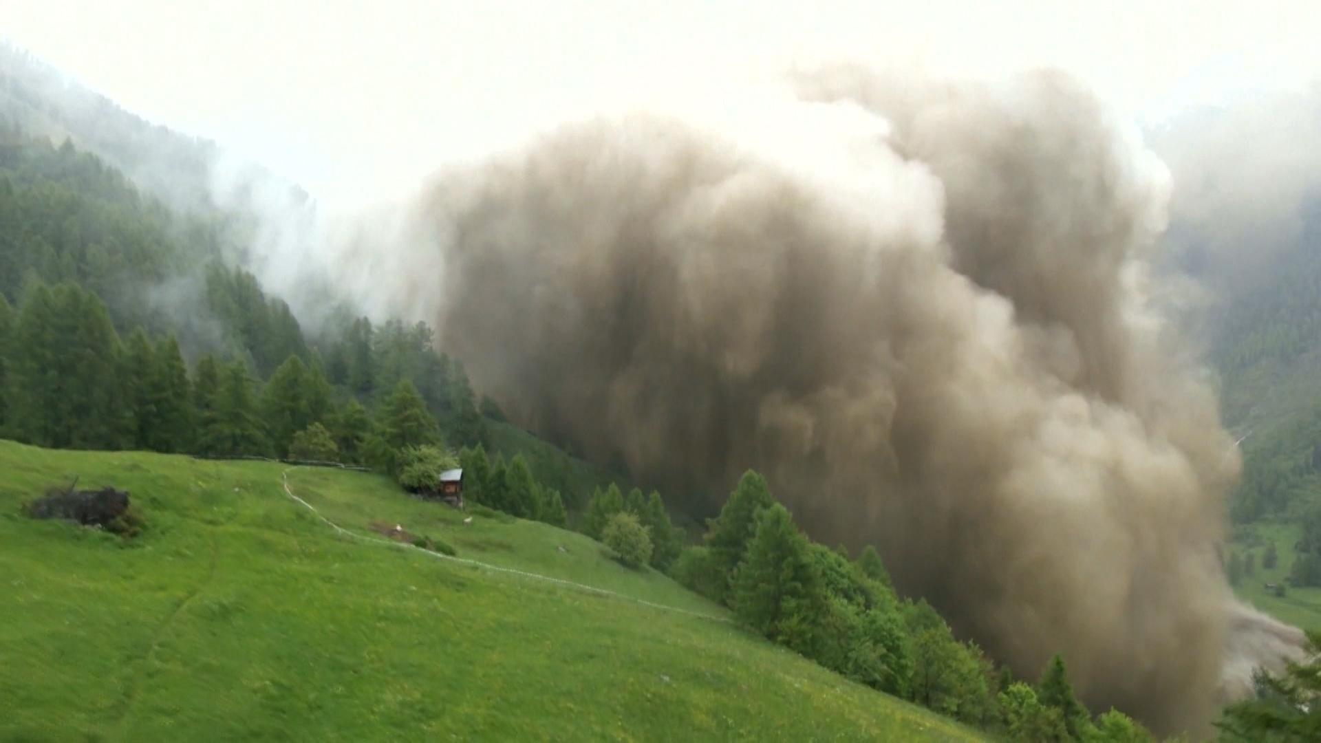 Eine riesige Staubwolke wälzt sich mit den Geröllmassen den Berg hinunter