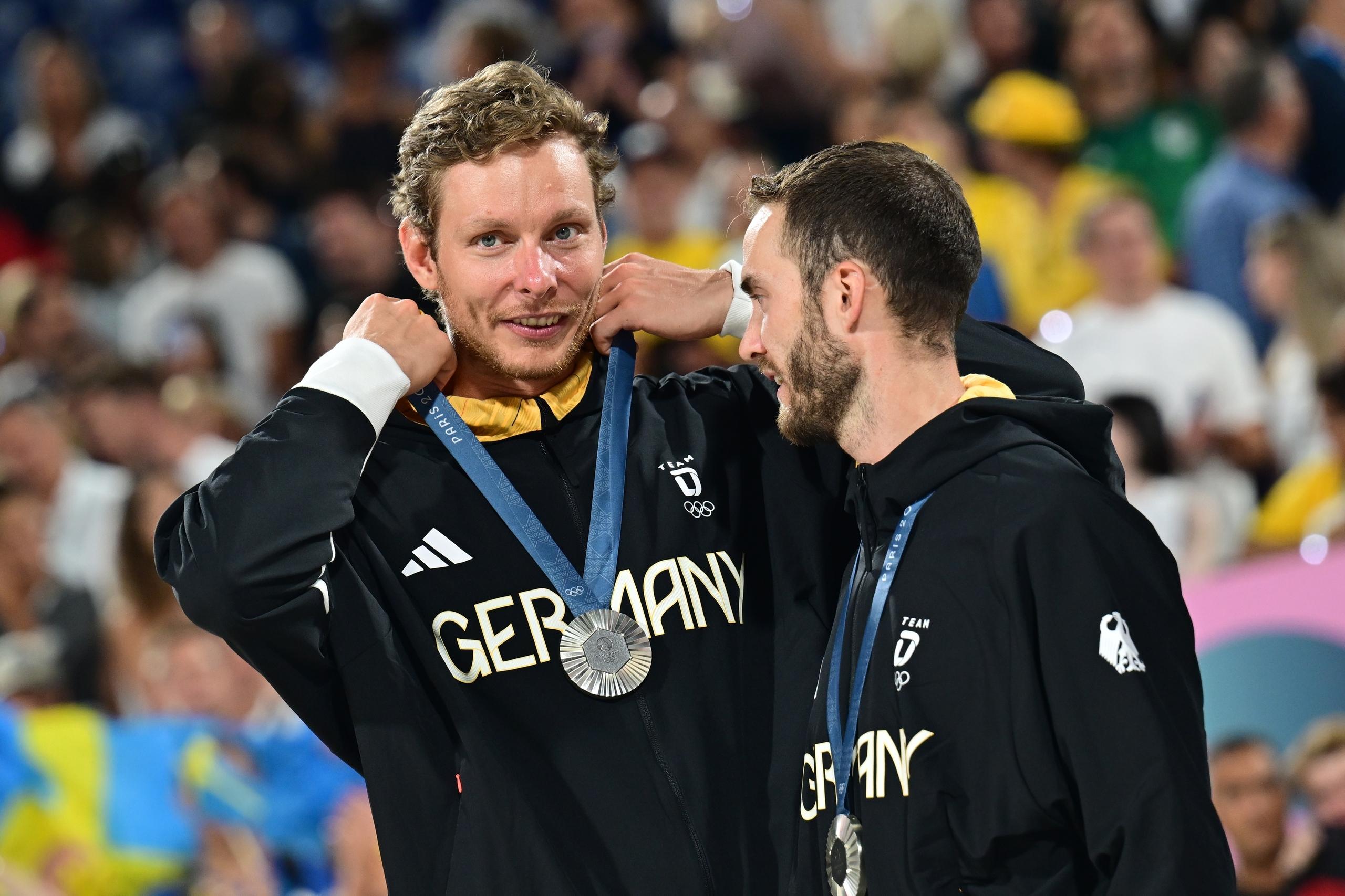Die Beachvolleyballer Nils Ehlers (l) und Clemens Wickler jubeln mit der Silbermedaille bei der Siegerehrung.