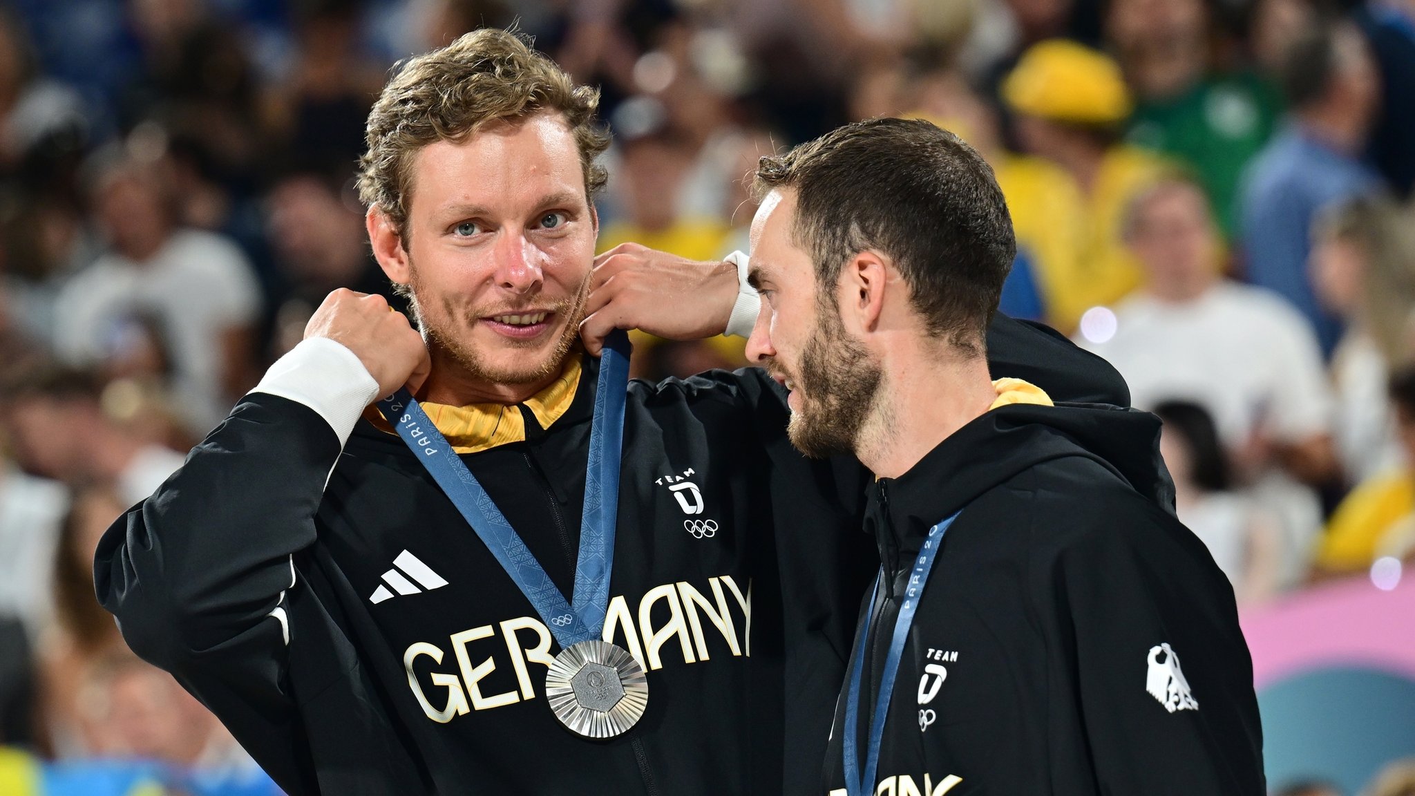 Die Beachvolleyballer Nils Ehlers (l) und Clemens Wickler jubeln mit der Silbermedaille bei der Siegerehrung.