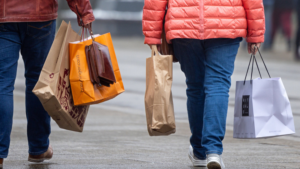 Kunden gehen mit Einkaufstüten durch eine Stadt