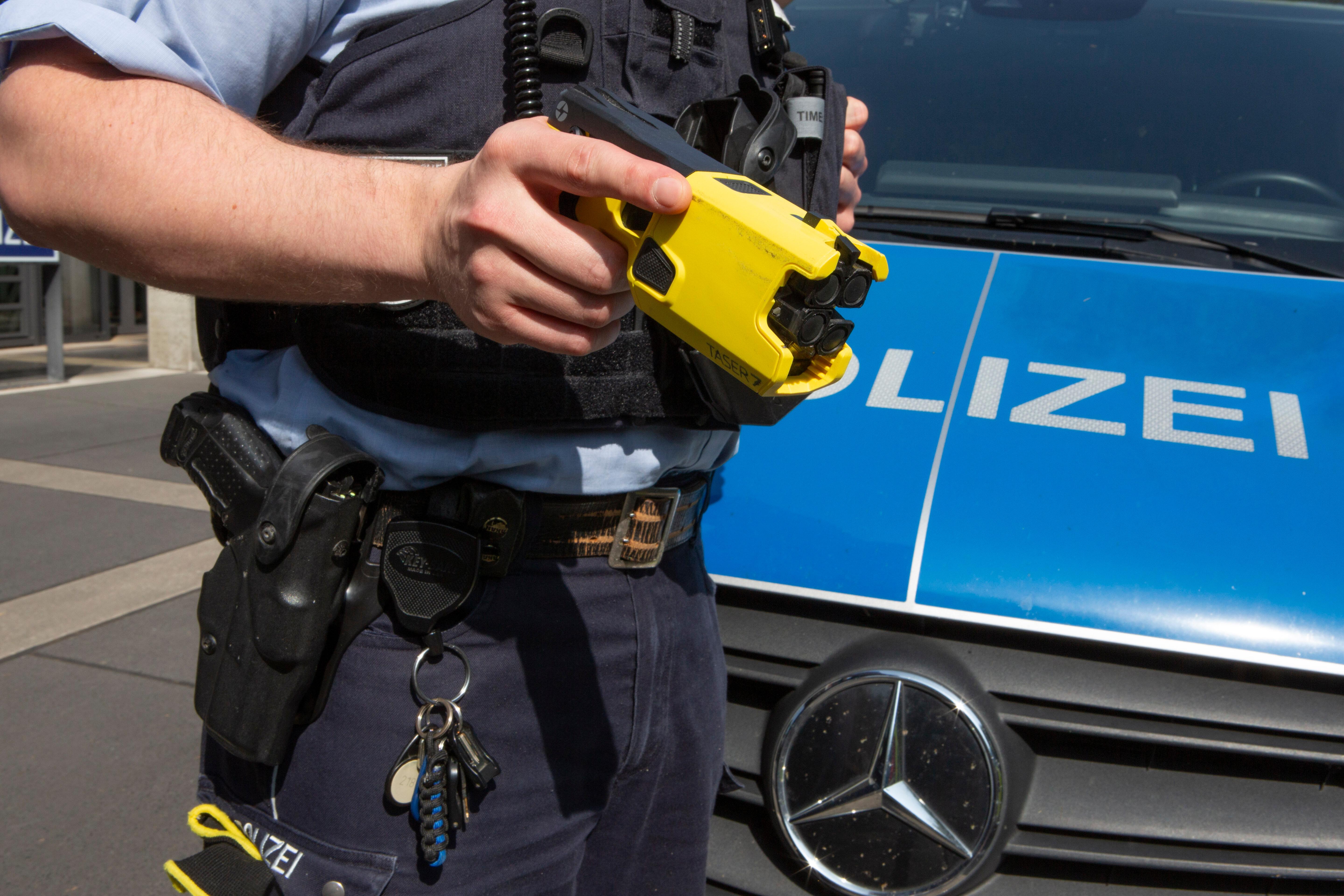 Polizeibeamter mit einem Taser | Bild:picture alliance / Ulrich Baumgarten | Ulrich Baumgarten