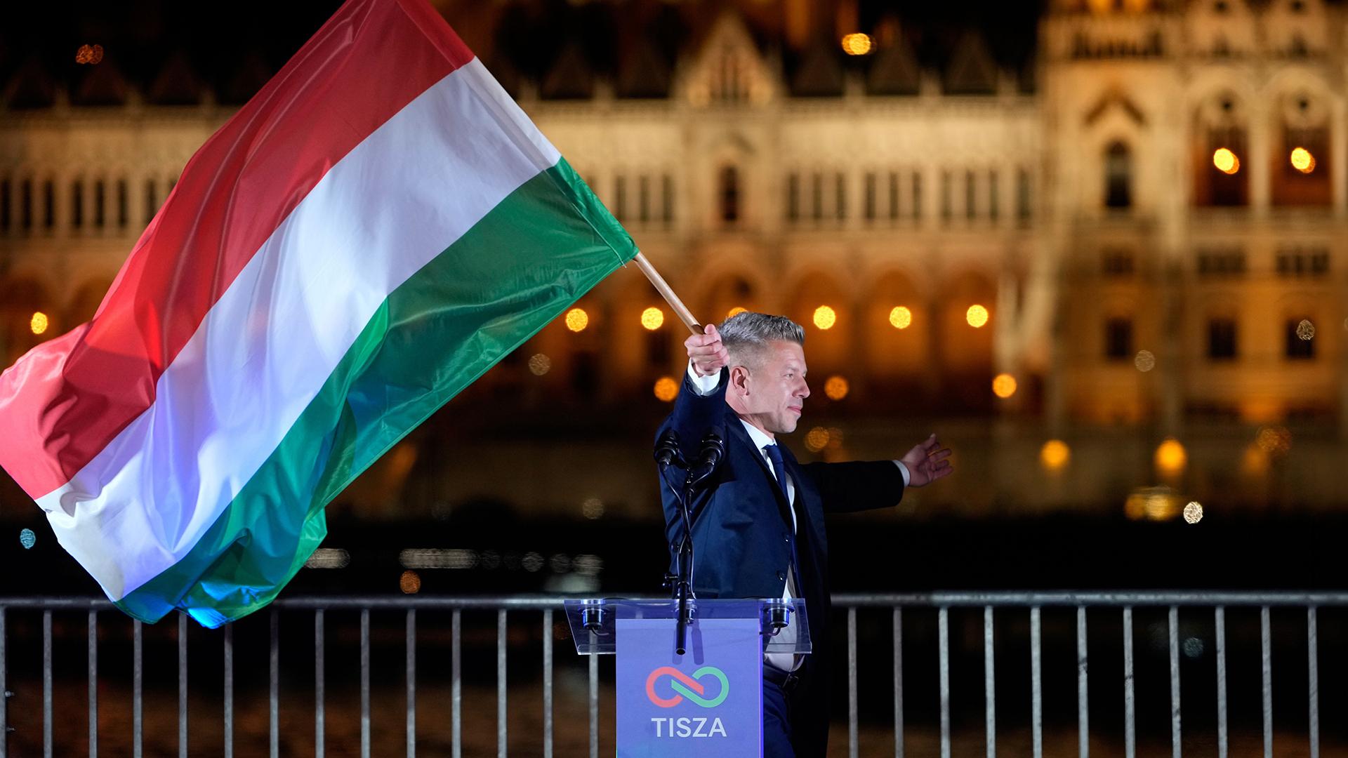 Péter Magyar schwenkt eine Ungarn-Flagge auf seiner Wahlparty in Budapest. 