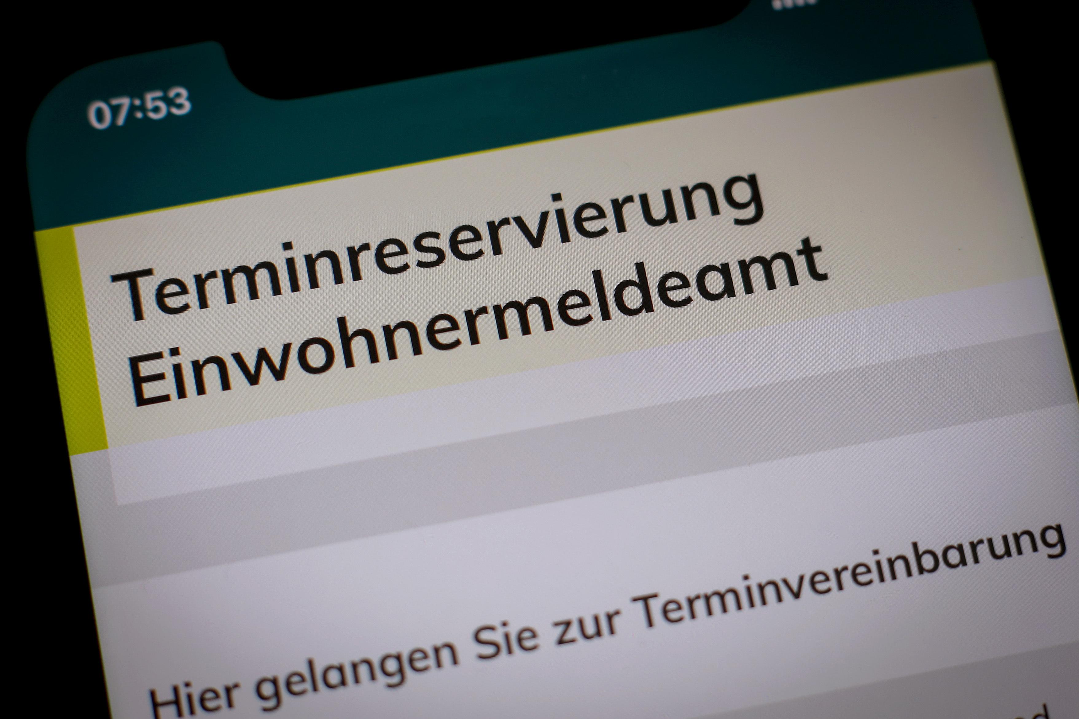 Auf einem Screen steht "Terminreservierung Einwohnermeldeamt".