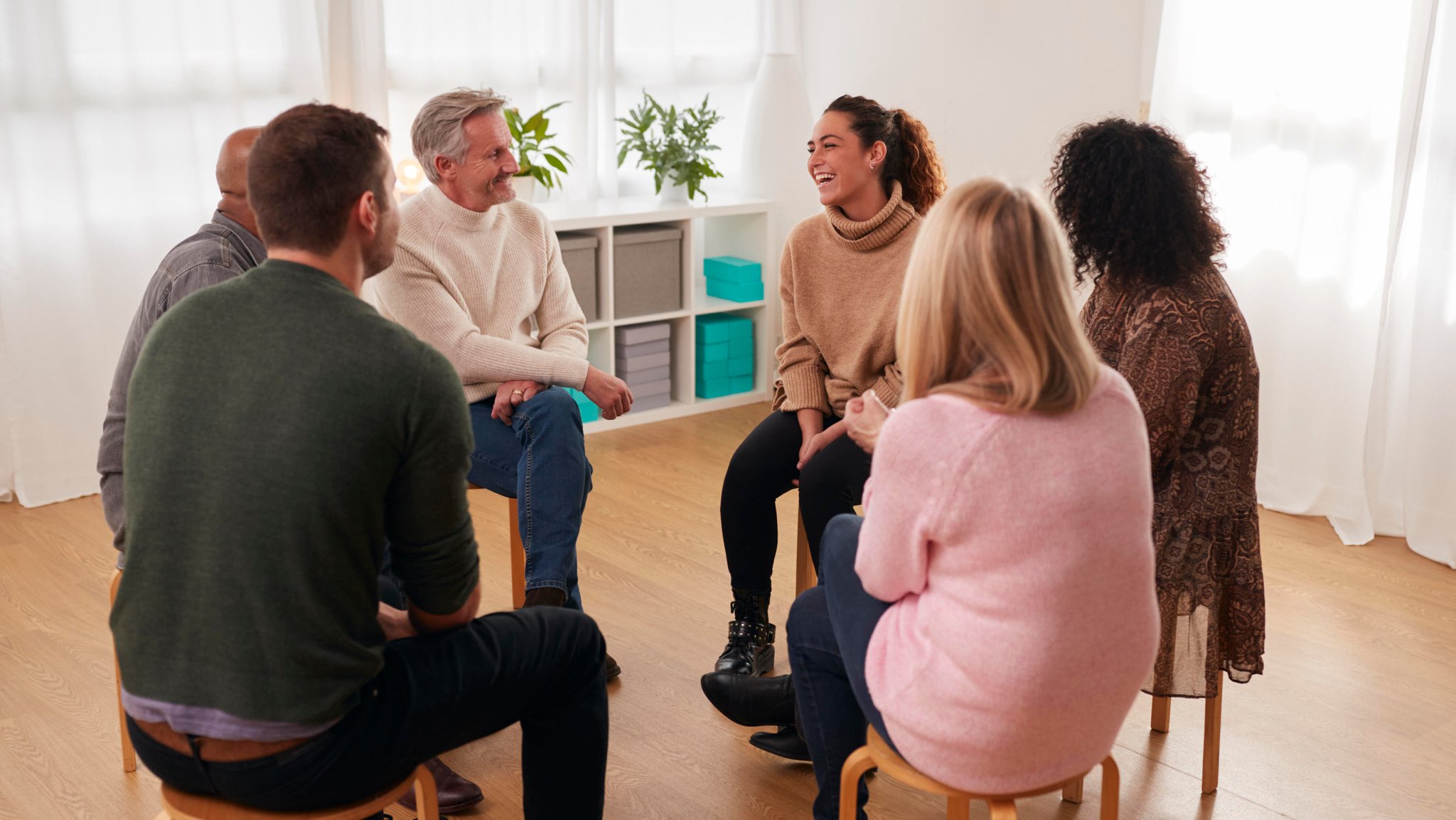 Sechs Erwachsene sitzen in einem Stuhlkreis und lachen. | Bild: picture alliance / Shotshop | Monkey Business 2 Sechs Erwachsene sitzen in einem Stuhlkreis und lachen.