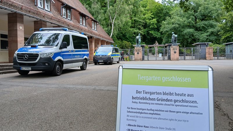 "Tiergarten geschlossen. Der Tiergarten bleibt heute aus betrieblichen Gründen geschlossen" steht auf einem Schild, das vor dem Eingang zum Nürnberger Tiergarten steht. Zwei Fahrzeuge der Polizei stehen daneben. | Bild: BR "Tiergarten geschlossen. Der Tiergarten bleibt heute aus betrieblichen Gründen geschlossen" steht auf einem Schild, das vor dem Eingang zum Nürnberger Tiergarten steht. Zwei Fahrzeuge der Polizei stehen daneben.