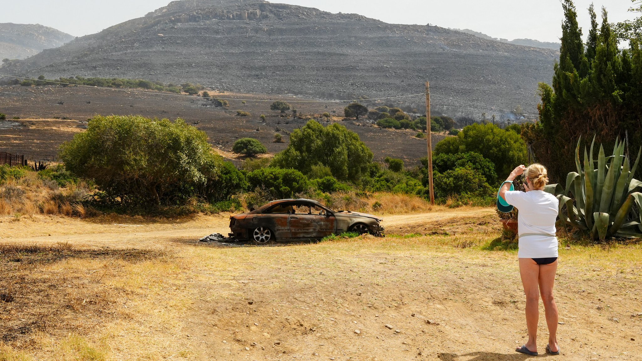 Vegetation und ein Auto wurden durch den Brand in Tarifa am 6. August 2025 im spanischen Andalusien verbrannt.