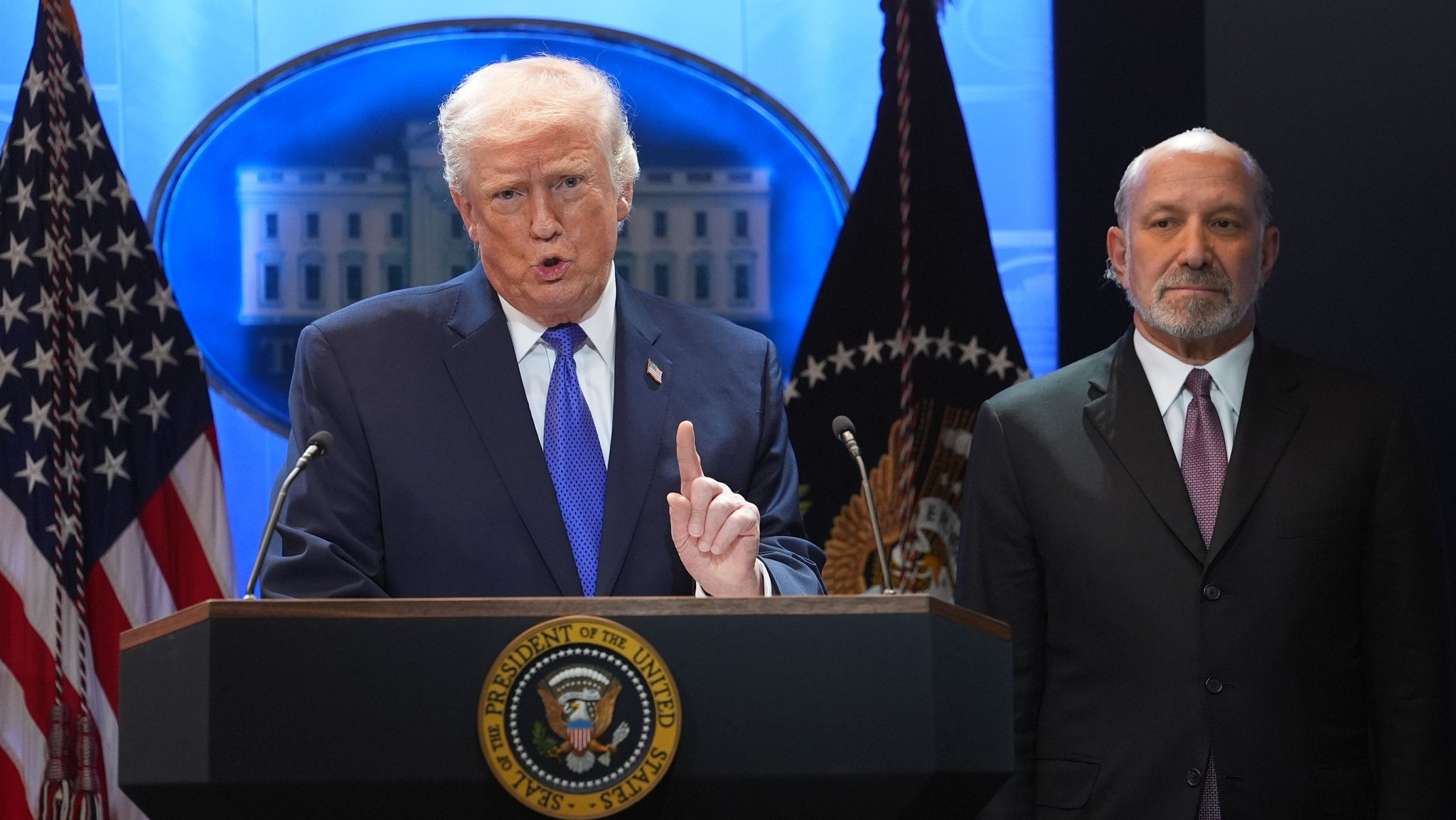 Zu sehen ist US-Präsident Donald Trump vor einem Redner-Pult im Weißen Haus. Neben dem Präsidenten steht Handelsminister Howard Lutnik. | Bild: dpa-Bildfunk/Evan Vucci Zu sehen ist US-Präsident Donald Trump vor einem Redner-Pult im Weißen Haus. Neben dem Präsidenten steht Handelsminister Howard Lutnik.