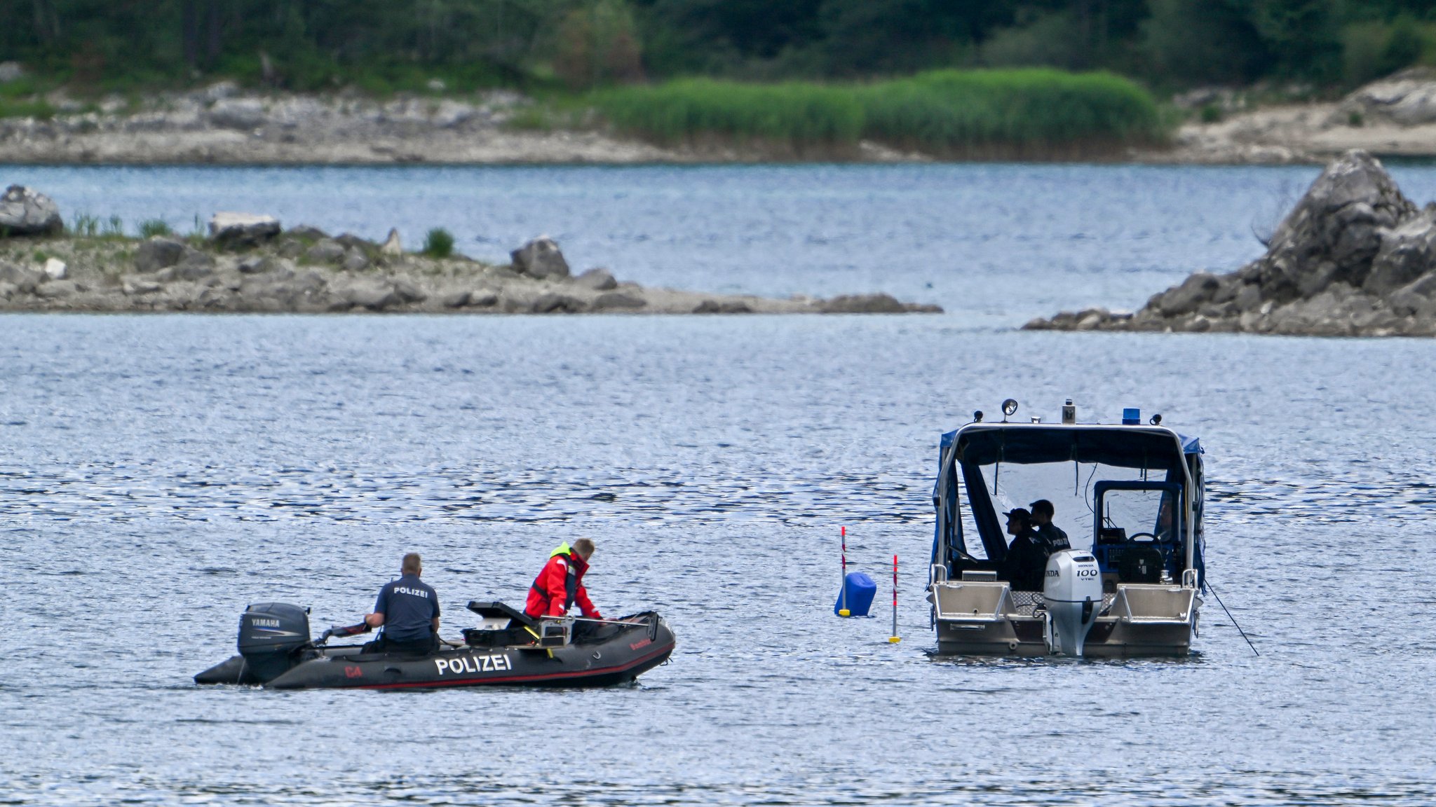 07.07.2025, Bayern, Grainau: Polizeitaucher mit Booten suchen auf dem Eibsee nach zwei vermissten Personen.