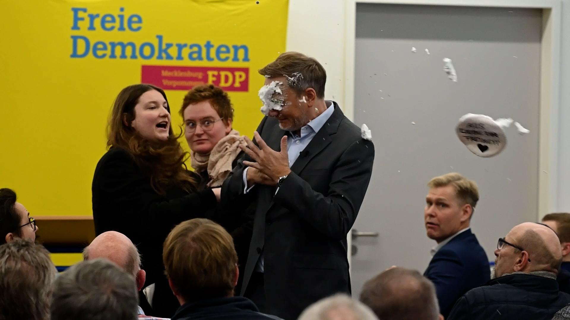 Der FDP-Vorsitzende Christian Lindner (M) bekommt bei einem Wahlkampfauftritt in Greifswald Schaum ins Gesicht. 