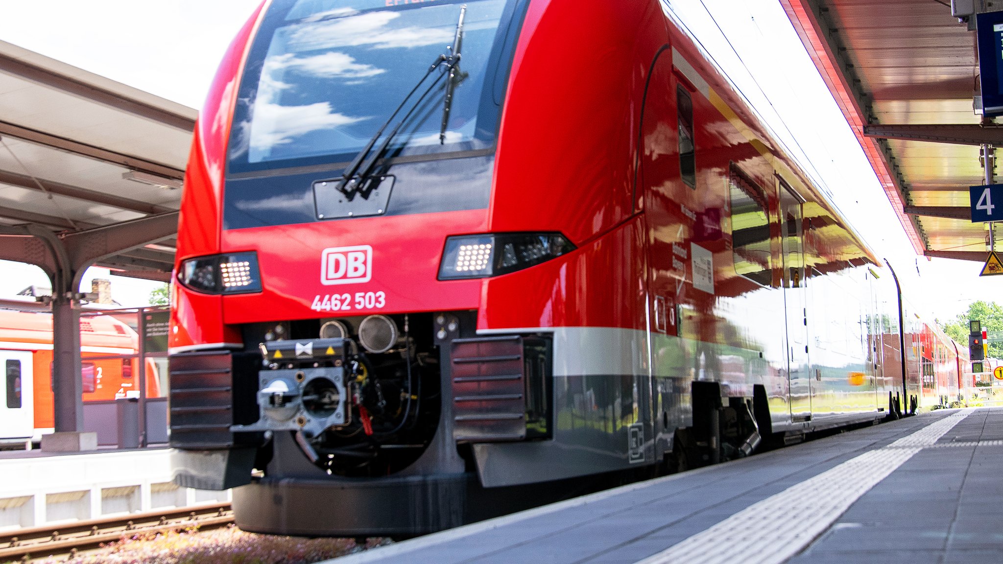 Ein roter Zug in einem Bahnhof.