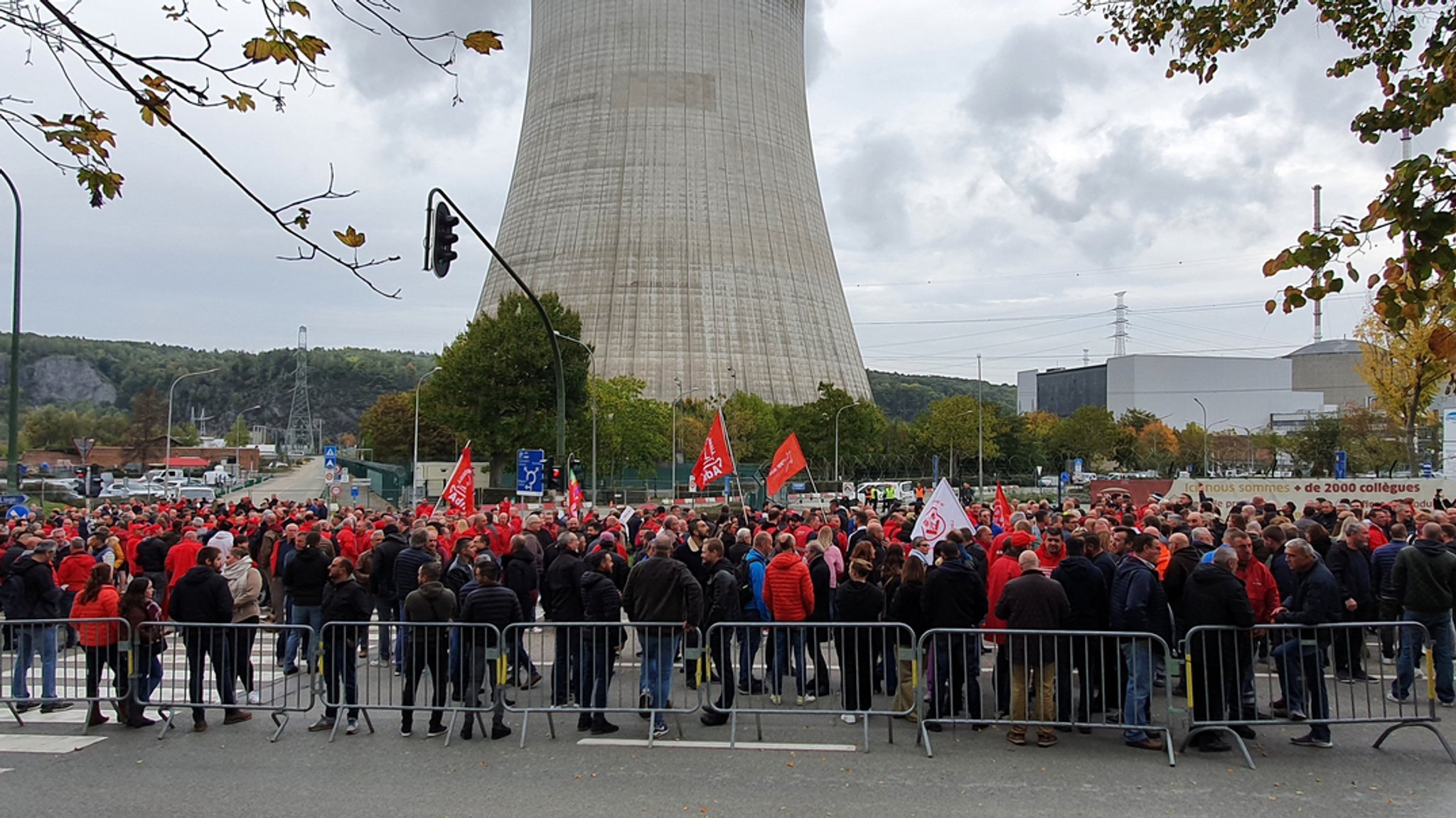 Eine Demonstration findet mit dem AKW Tihange im Hintergrund statt.