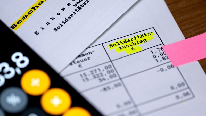 Das Wort "Solidaritätszuschlag" ist neben einem Taschenrechner auf einem Steuerbescheid zu sehen | Bild: picture alliance/dpa | Sven Hoppe Das Wort "Solidaritätszuschlag" ist neben einem Taschenrechner auf einem Steuerbescheid zu sehen