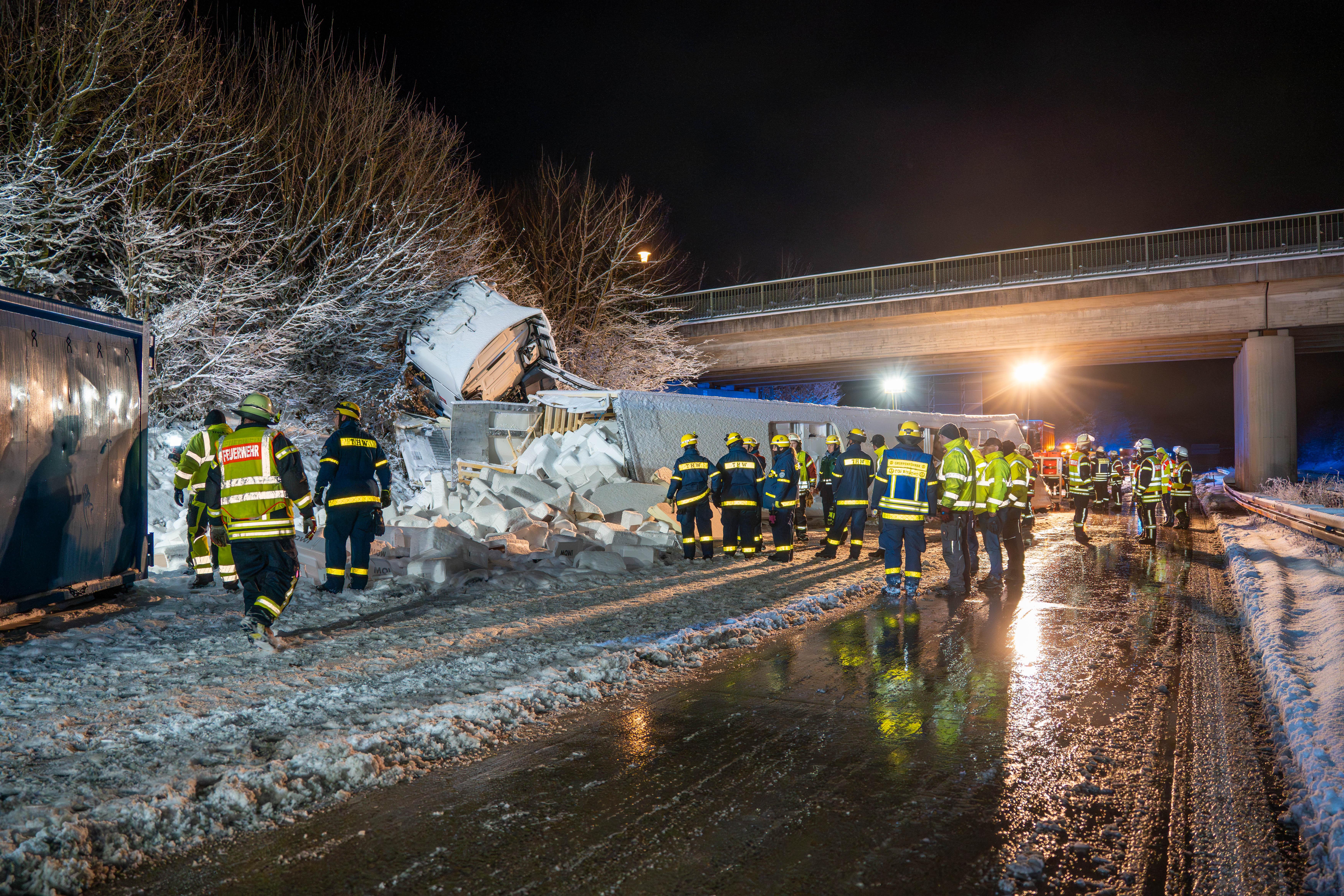 Zahlreiche Einsatzkräfte versammeln sich um einen umgekippten Lastwagen.