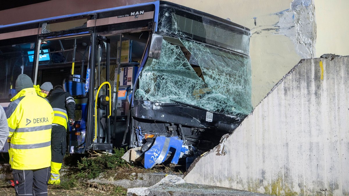31.01.2026 in München-Trudering: Ein Linienbus wird nach seinem Aufprall auf eine Betonmauer geborgen. Bei dem Unfall kam ein 13-jähriges Mädchen ums Leben, mehrere wurden verletzt. 